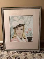 Full view of the framed art showing the woman wearing a hat portrait with mat and frame