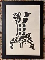 Full view of the framed totem art print showing black and white stylized animal figures in totemic style.