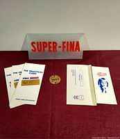Lot contents showing the Super-FINA glass sign, brass capacity tag centered, and four PetroFina credit card applications fanned out.