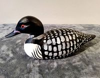 Front side view of wooden handpainted loon showing black and white feather details and red eyes