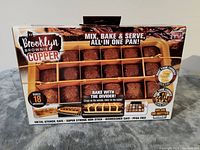 Front view of Brooklyn Brownie Copper boxed pan showing brownie divisions and marketing text