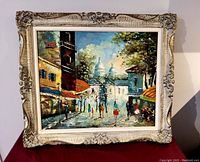 Front view of the framed oil painting showing the Paris street scene with people and buildings under a bright sky.