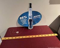 Photo showing AC Delco advertising sign shaped like a spark plug with a measuring yardstick below for scale, displaying full size and condition.