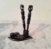 Front view of entire ebony wood hippo pipe set showing two pipes standing on leaf-shaped stand with small hippo carving