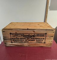 Front view of wooden crate with Rawleigh's printed advertising showing company locations and glass care warnings