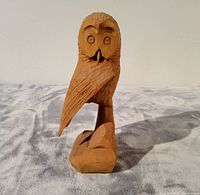 Front view of vintage wooden owl carving showing the hand-carved detail, natural wood finish, and the owl's folded wing and expressive features.