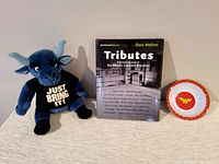 Three-item lot showing the plush bull, wrestling book, and child's bowl.