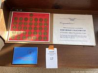 Full view of the coin set on red board with original box and booklet