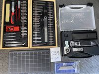 Full lot view showing the Master grip hobby set in a wooden case next to the Craftsman cutter kit in a plastic case and an unopened Kobalt utility cutter pack. Includes a small cutting mat.