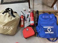 Full lot group showing Intex inflatable mattress bag, emergency supply backpack, two fire extinguishers, flashlights and preparedness case.