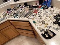 Overall view of assorted necklaces, earrings, bracelets, and pins displayed on countertop