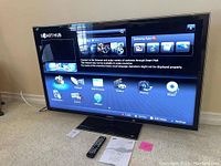 Front view of Samsung 60" TV powered on showing Smart Hub home screen