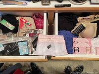 Wide drawer view showing various new women's undergarments including bras, hosiery tanks, and shapewear with tags from different brands including Bali and Victoria's Secret.