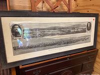 Full view of the framed panoramic military print displayed on a wooden chest