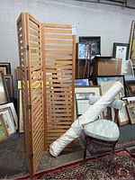 Three panel wooden room divider standing open with horizontal slats and brass hinges. Photos show front and side views highlighting the structure and condition which needs cleaning.