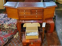 Wooden sewing chest with drawers and side compartments, sewing stitcher in box, and vintage wooden notions box below.