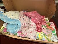 Folded floral pattern aprons in cardboard box