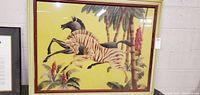 Full view of the framed signed wall art showing two horses and a colorful botanical scene with a bamboo-style frame.