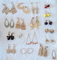 Top view showing all 18 pairs of vintage pierced earrings on a white cloth background.