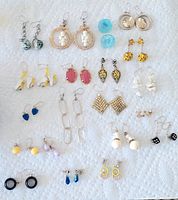 Full lot of 20 pairs of vintage pierced earrings displayed on white textured background