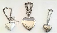 Three vintage chunky silver-tone charm bracelets with puffy heart pendants displayed on white background.