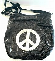 Full view of the black nylon sequin tote bag with peace sign and adjustable strap.