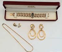 Anne Klein gold-tone bracelet watch in original box with assorted jewelry: chain necklace, large drop earrings, and clip-on earrings