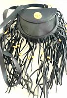 Front view of vintage black leather handbag with leather fringes and gold-tone hardware.