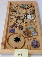 Full view of assorted costume jewelry in wooden tray