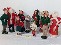 Full set of ten Byers Choice Carolers displayed in a group on white background, showing variety of characters including two Santas, skaters, and carolers in Victorian-style clothing and accessories.
