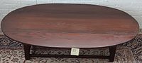 Top view of the vintage Cushman Classic drop leaf coffee table showing oval wooden top with dark wood grain finish.
