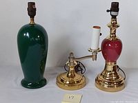 View showing all three lamps together: green ceramic lamp, brass adjustable arm lamp, red ceramic lamp.