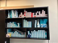 Front view of black floating shelf filled with various boxed hair color products and supply bags