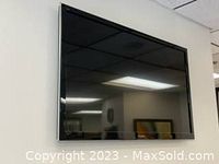 Front view of 42-inch Panasonic flat screen TV powered off showing reflective screen and slim bezel.