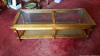 Top view showing the rectangular wooden coffee table with two glass panels and visible corner scuff.