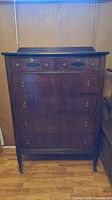 Front view of the vintage dresser showing six drawers with metal ring pulls and lock keyhole on top drawer.