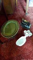 Overall photo showing all items: vintage iron, chafing dish, gravy boat and four egg cups on red carpet