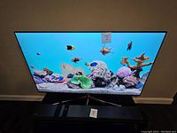 Front view of TV on stand with soundbar and remote