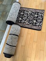 Two rolled carpet runners stacked, backside non-slip underlay visible