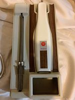 Westinghouse electric carving knife housed in molded plastic case with faux woodgrain accents, power cord visible.