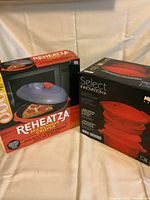 Two boxed microwave gadgets; Reheatza Microwave Crisper and Meyer Select Innovation Microwave Pressure Cooker