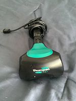 Top view of Thumper Mini-Pro massager showing logo and power cord coiled