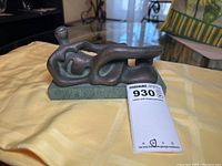 View of bronze abstract reclining female figure sculpture on marble base from front right angle