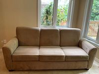 Front view of the camel microfibre sofa showing three cushions and armrests with surrounding windows providing natural lighting.