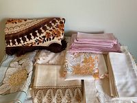 Folded assorted linens and apron piled on a flat surface