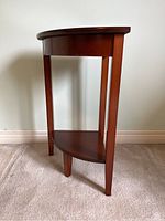 Front and side views of the wood corner table showing the semi-circular shape and lower shelf.