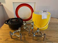 Lot items include mid-century modular metal candlesticks, cast iron pot, and a white tray with circular design.