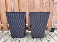 Front view of two brown resin garden planters with wicker texture, side by side on a wooden deck.