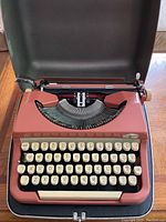 Front view of pink Simpson vintage typewriter showing keyboard with cream keys and visible typebars.