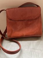 Front view of the reddish-brown vintage Diamicci leather handbag with shoulder strap.